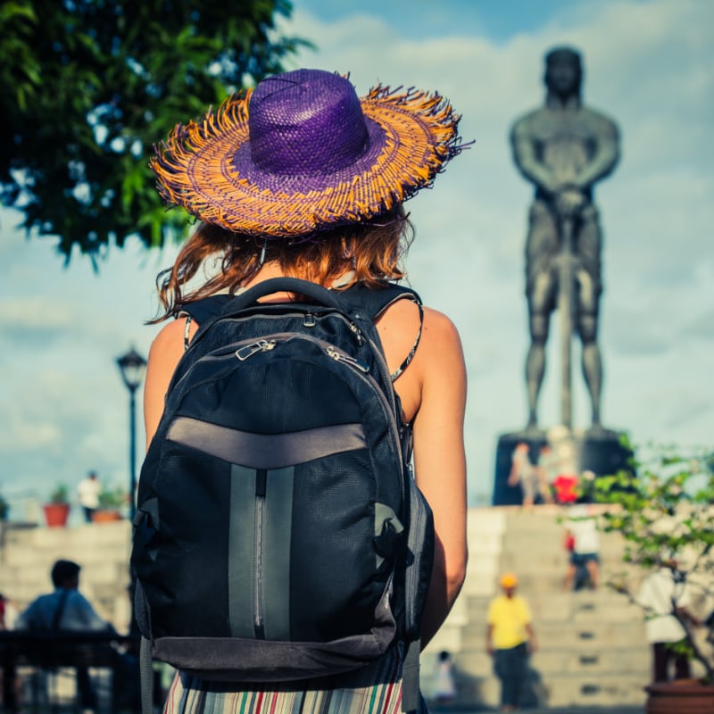 A Young Woman Looking At A Statue In Manila, Philippines, Southeast Asia