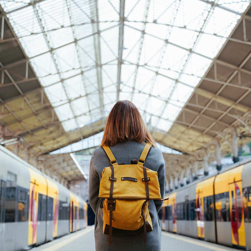 Female Backpacker Preparing To Board A Train In Europe, Unspecified Location