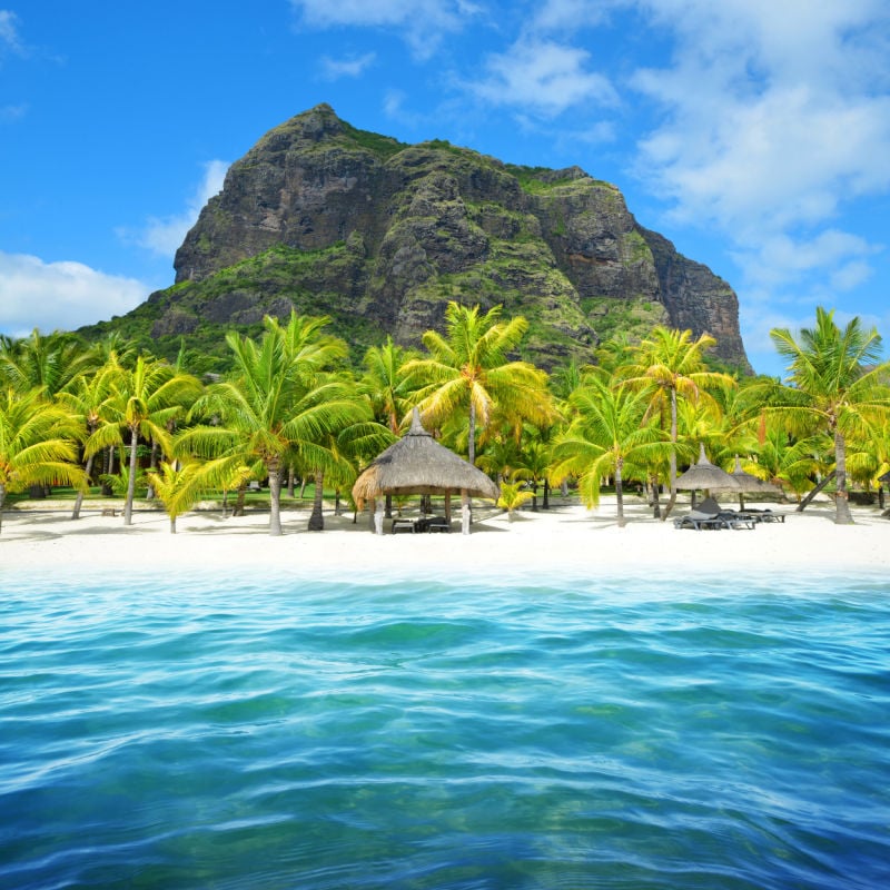 the inviting beach of Mauritius with a mountain in the background, as seen from the water