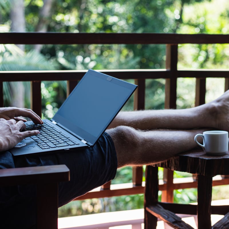 Digital Nomad Working Barefoot With Coffee