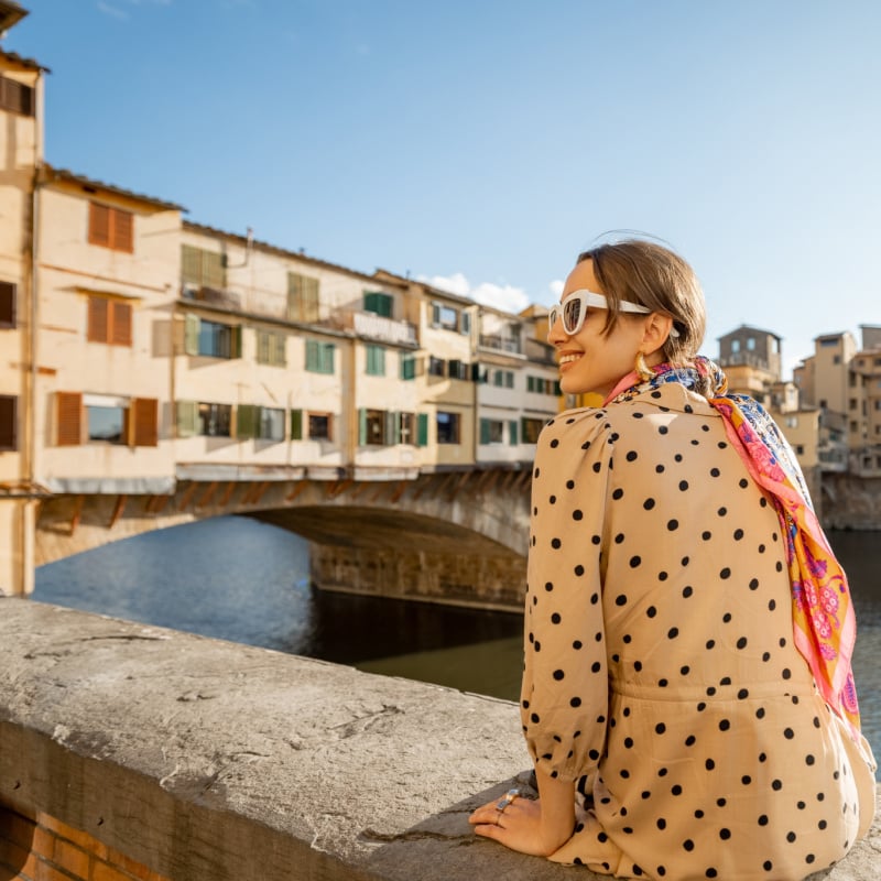 woman looks at ponte vecchio bridge in florence italy