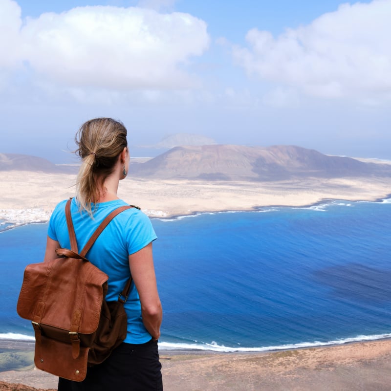 woman solo traveler looking out at la graciosa island in lanzarote canary islands spain