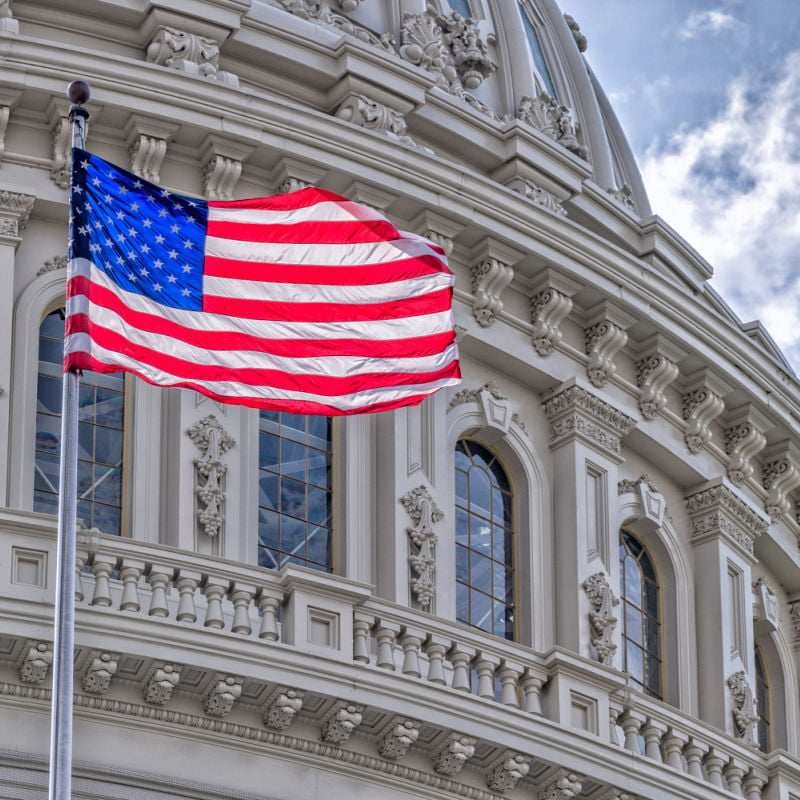 Washington DC Capitol dome with waving American flag