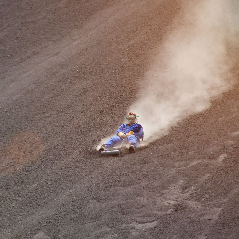 a man sandboarding down Cerro Negro Volcano in nicaragua