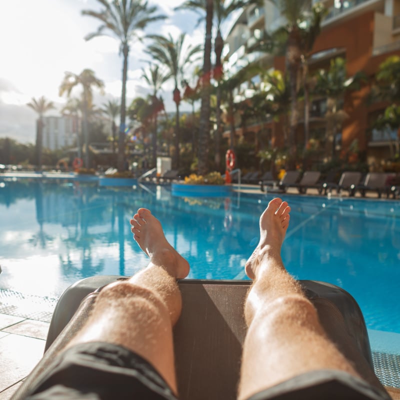 man lounging at resort pool in madeira