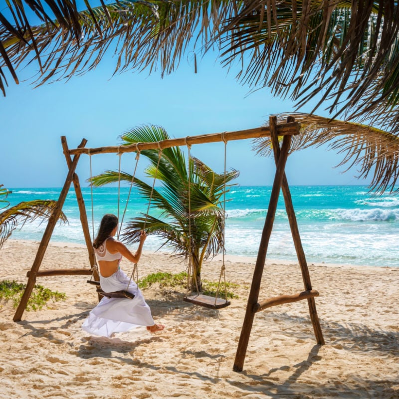 woman on a swing in Tulum, Mexico