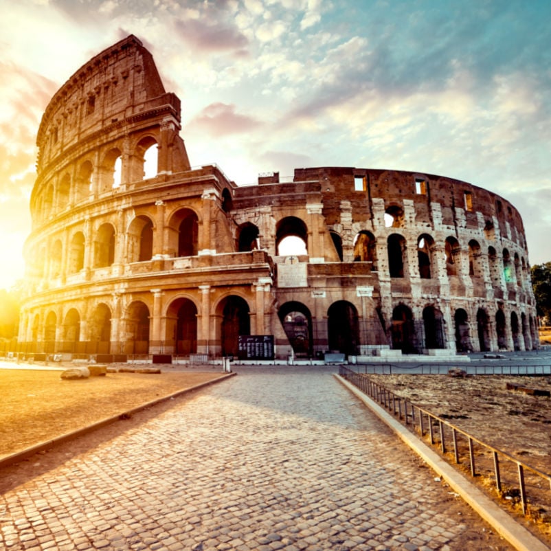 view of the colosseum in rome with a beautiful sunset behind