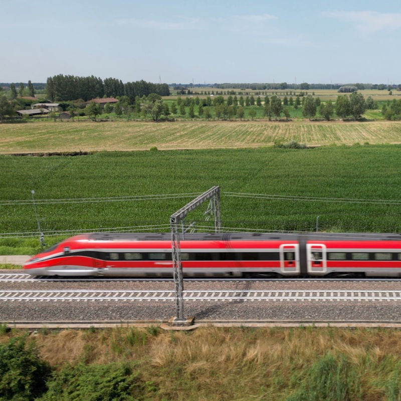 a Frecciarossa high speed train moving through the countryside in italy