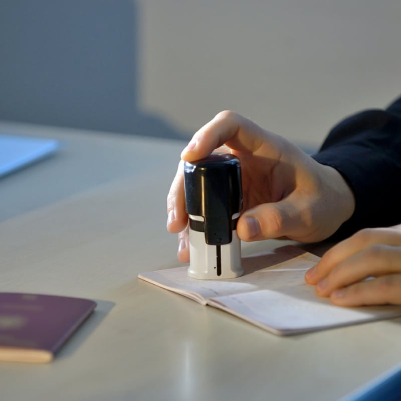 Customs Agent Stamping A Passport