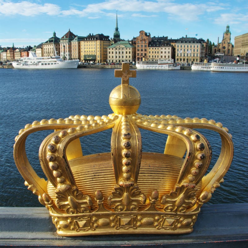 gold crown on a bridge in stockholm with royal palace in the background