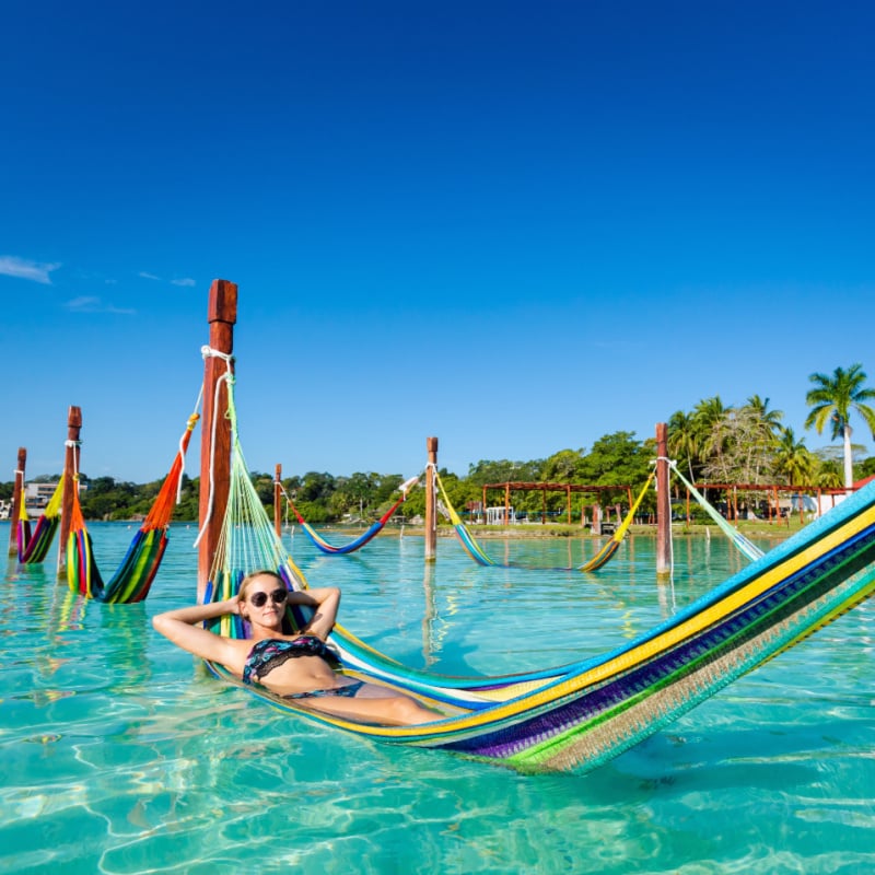 Tourist Relaxing On A Hammock In Bacalar, The Mexican Caribbean, Mexico