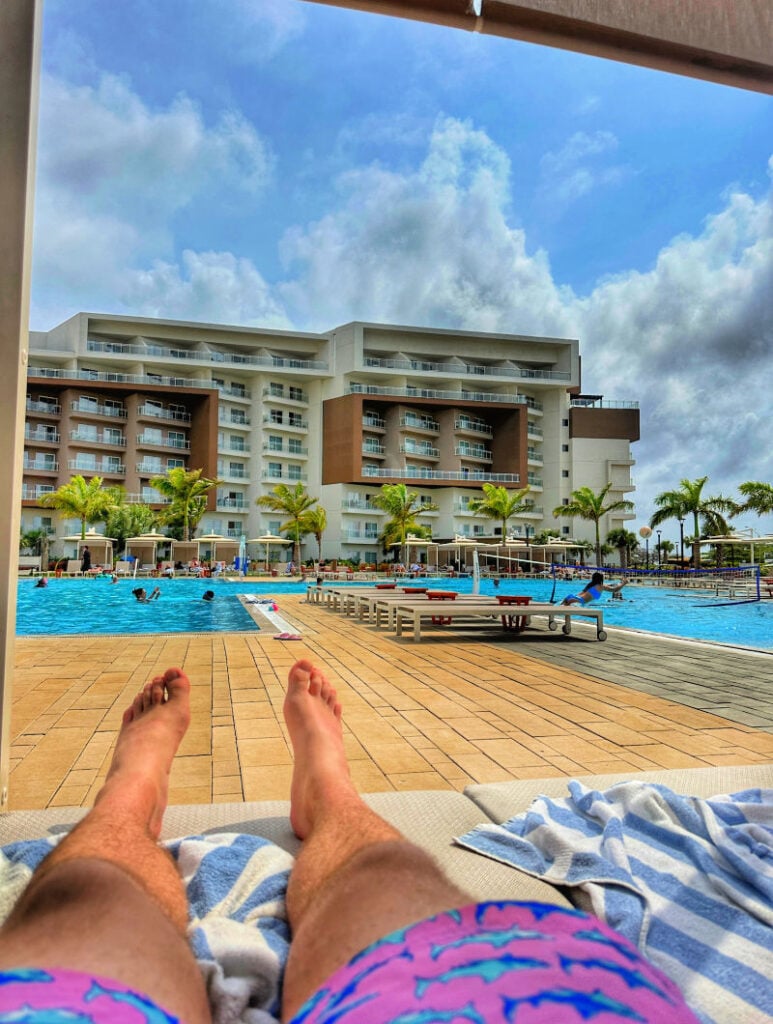 Man sitting by pool at the Embassy Suites Aruba