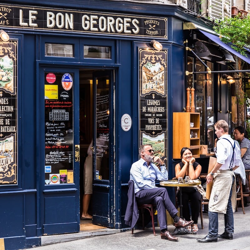 Paris, France - June 16, 2017: The charming Cafe Le Bon Georges. Parisians and tourists enjoy food and drinks at the street french cafe.