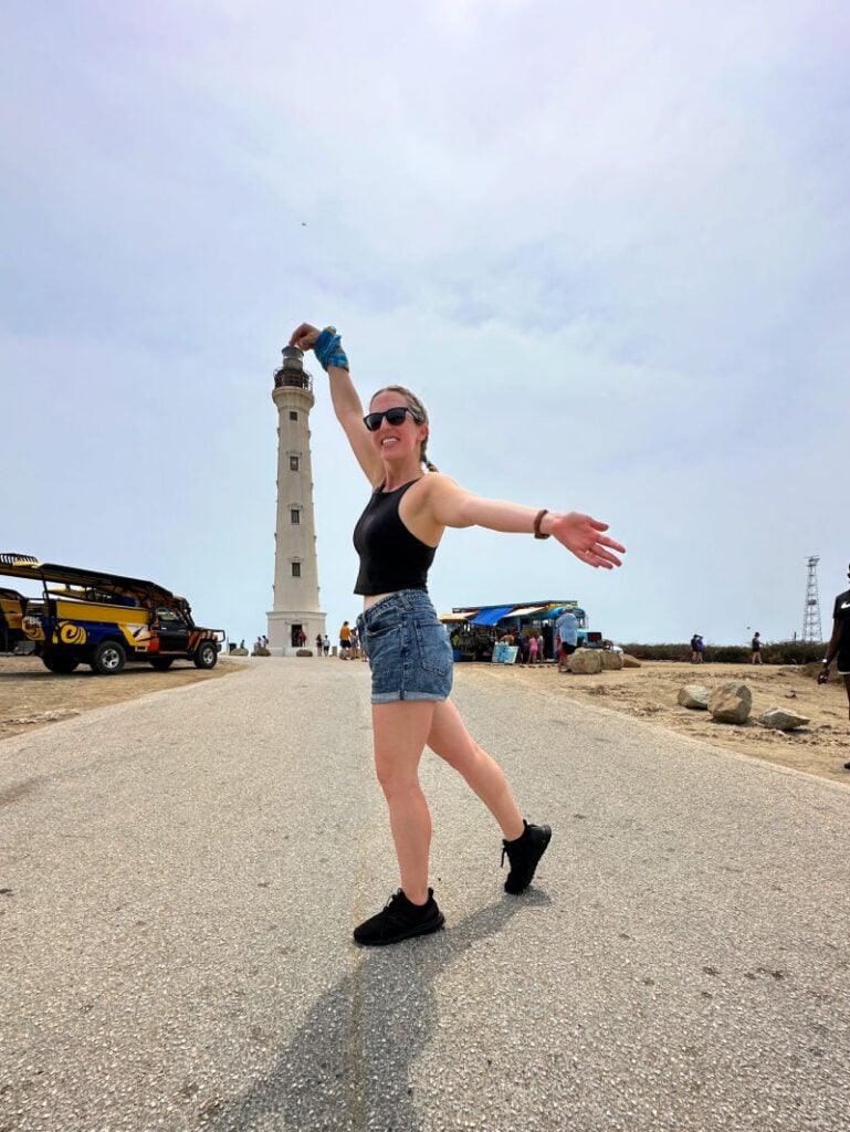 Woman posing with the California Lighthouse in Aruba