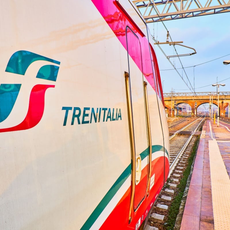 A train of Trenitalia in an Italian train station at sunset. Asti, Piedmont, Italy.