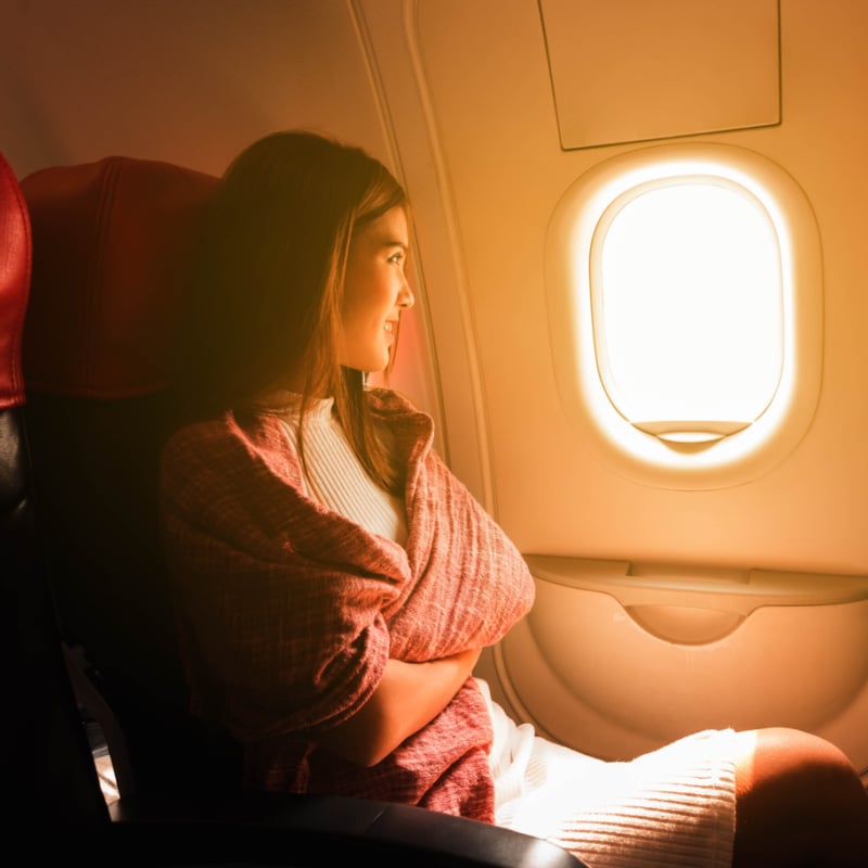 Female passenger looking out airplane window