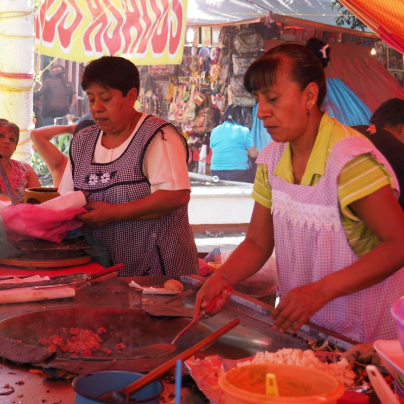 Two women cook street food in Mexico City