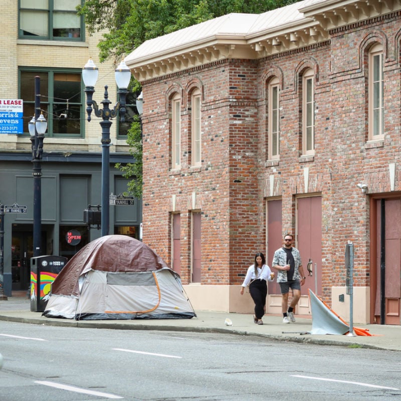 People walking by tent on sidewalk in Portland, Oregon