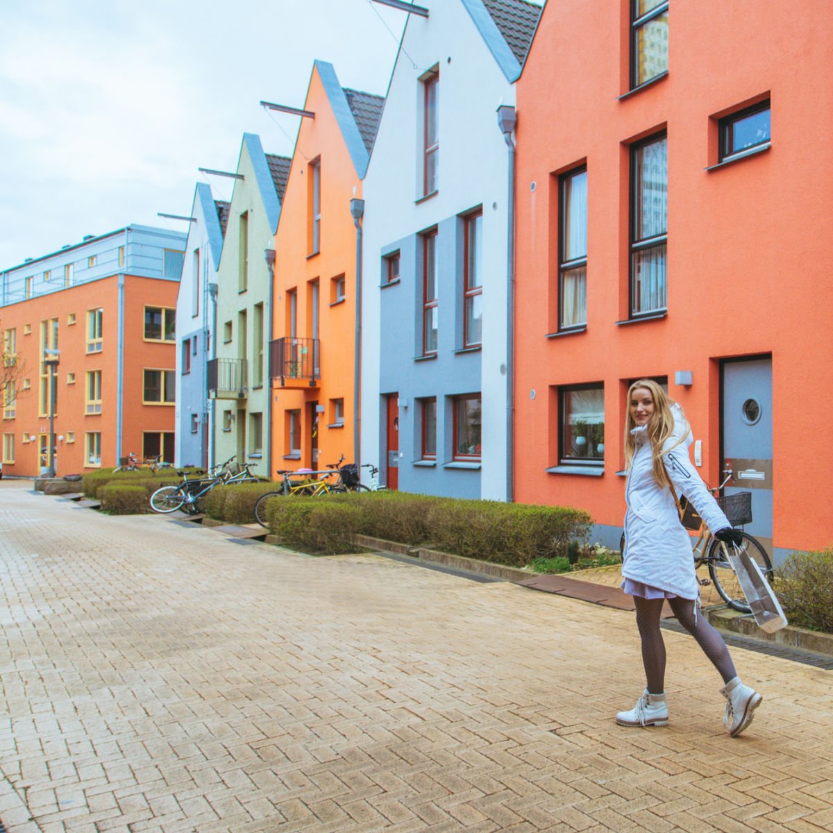 Female solo traveler walking past colorful homes in  Malmo, Sweden