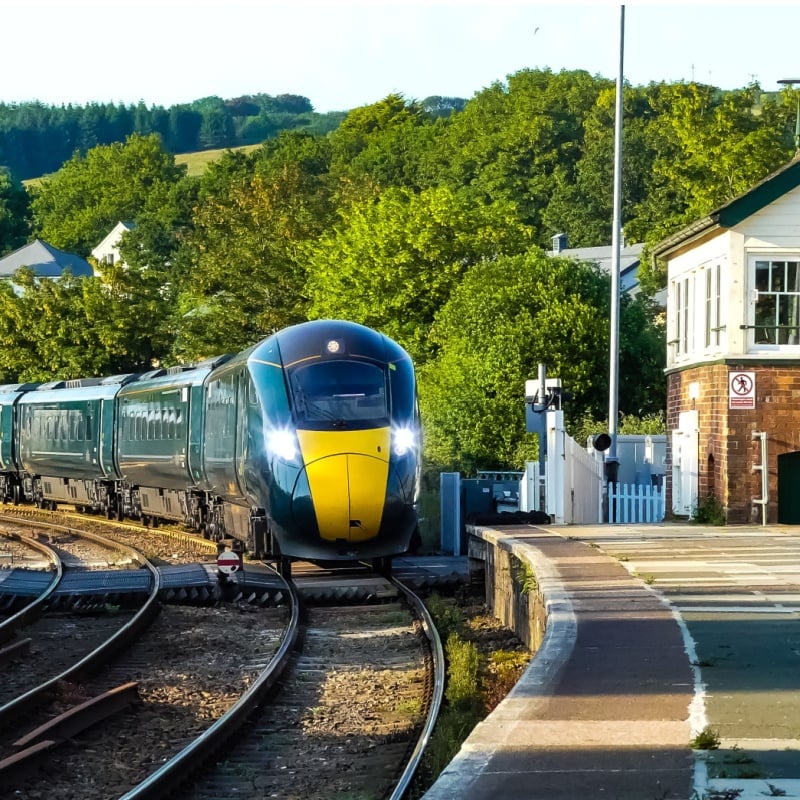 The Great Western liveried 800 series train and coaches passes by the signal box on the down line to Penzance.