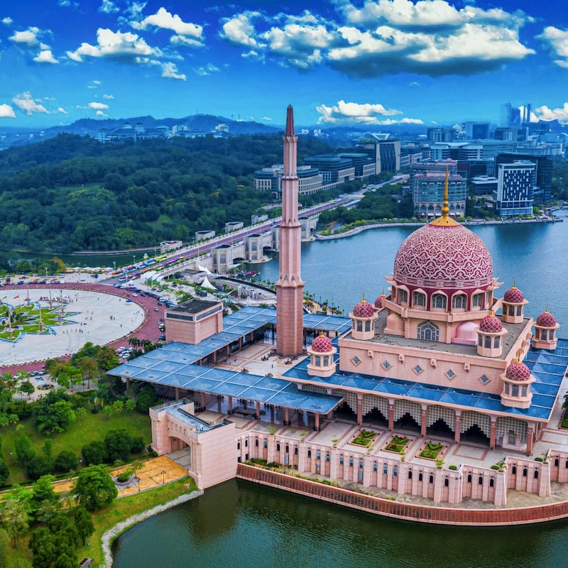 Aerial View Of Putra Mosque with Putrajaya City Centre with Lake at sunset in Putrajaya, Malaysia.