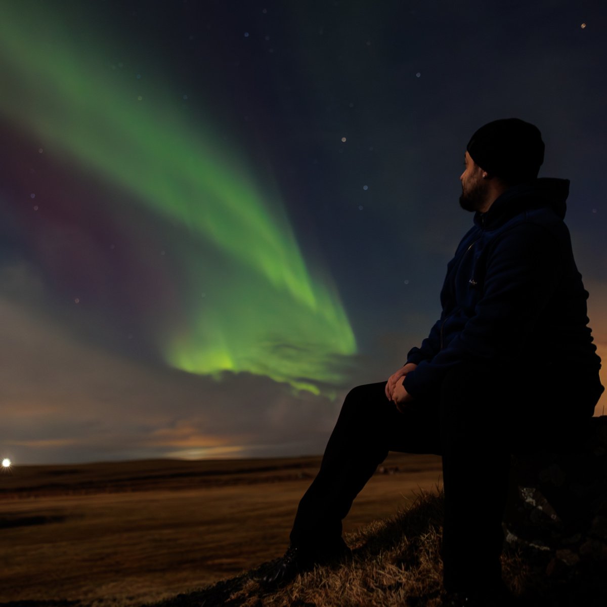 Man observing Northern Lights at night in Iceland