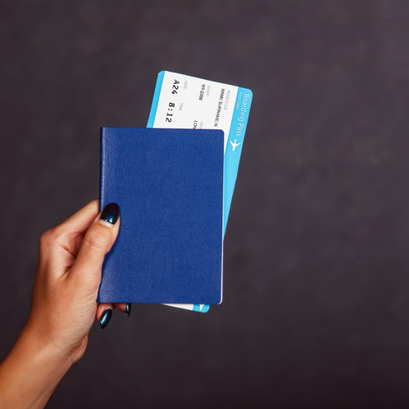 Woman holding a passport and a plane ticket