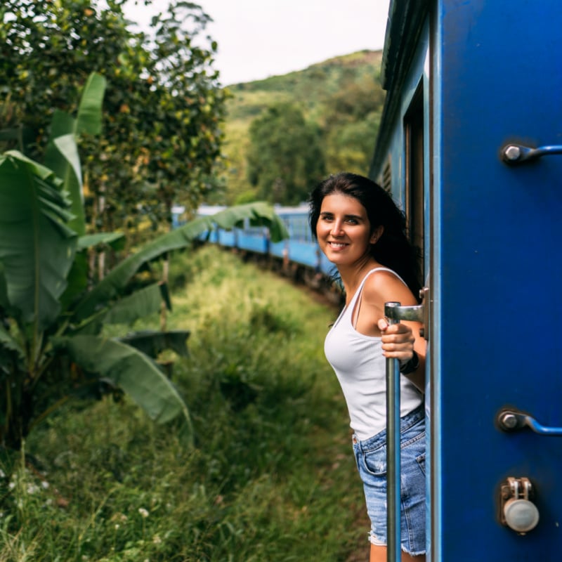 Woman Riding Train Through Forest In Sri Lanka, South Asia