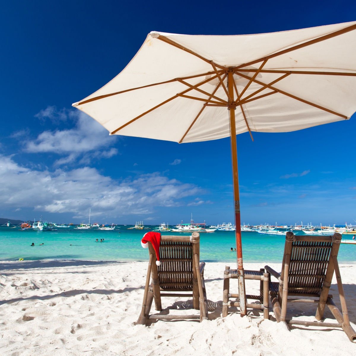 Sun umbrella and a santa hat on a beach in the Bahamas