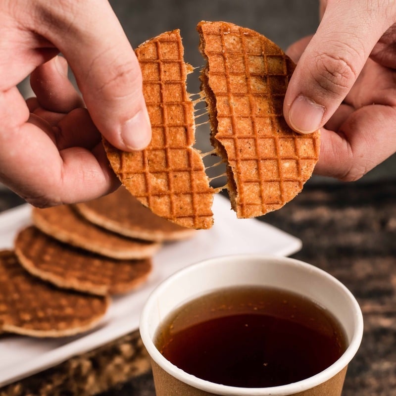 Tourist Eating Stroopwaffels And Drinking Coffee In The Netherlands